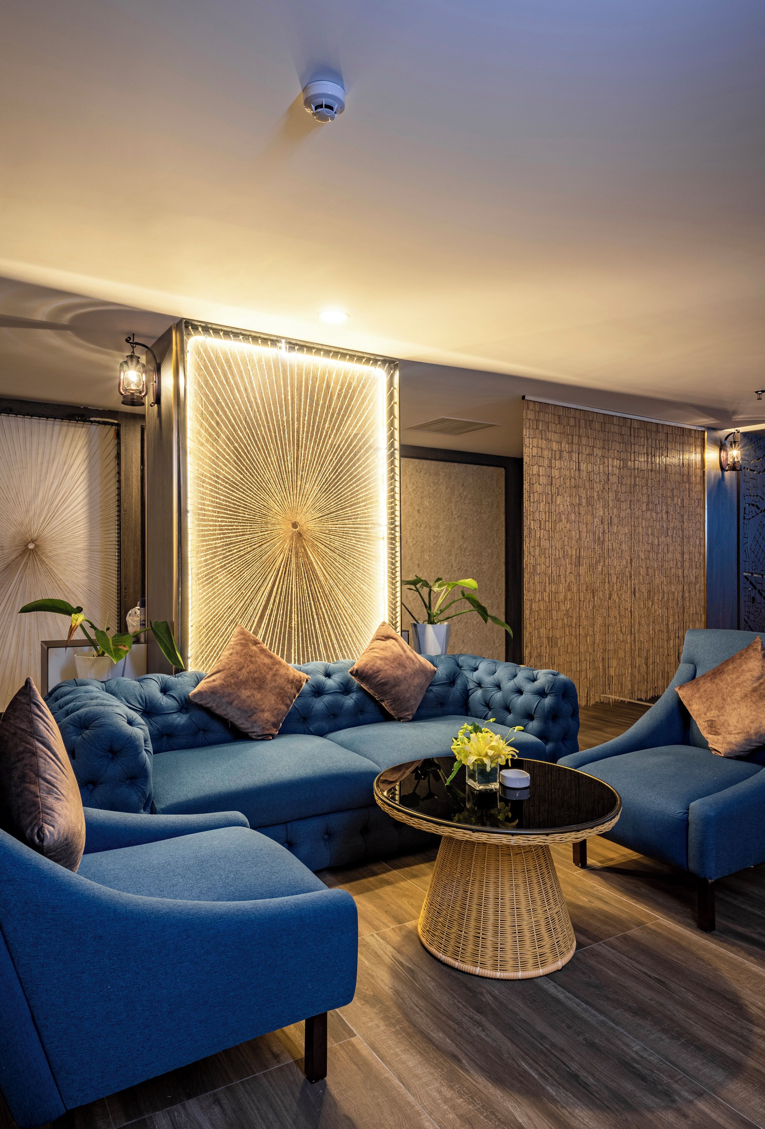A modern living room with a sectional sofa, a round coffee table, and a decorative wall panel.