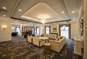 A spacious living room with a chandelier, sofas, a coffee table, and a fireplace.