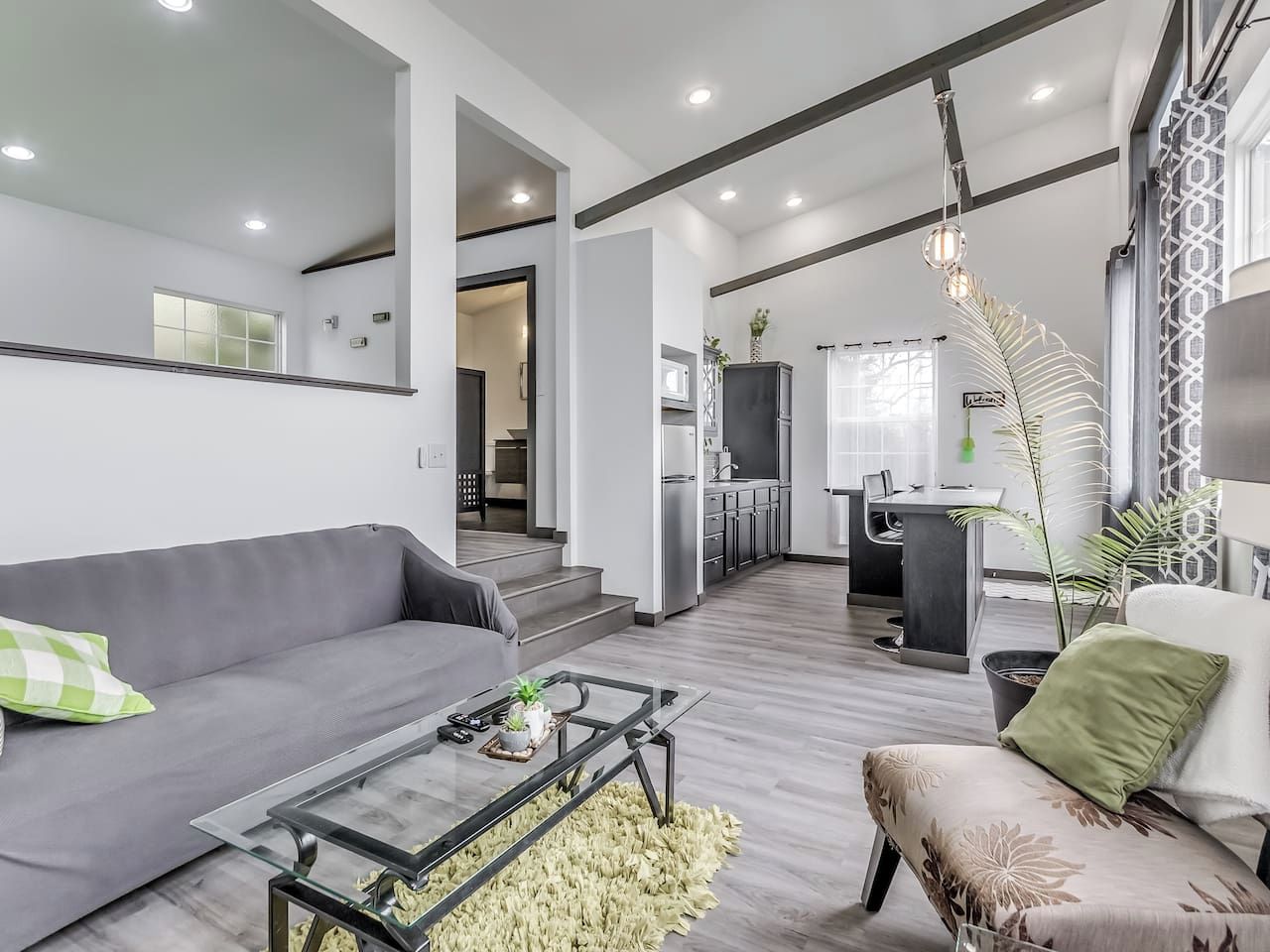 Een moderne woonkamer met een bank, salontafel en een eethoek met een stoel.