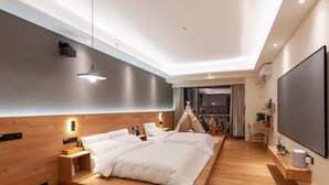 Une chambre moderne avec un grand lit, des tables de chevet, une télévision et une vue sur la ville la nuit.