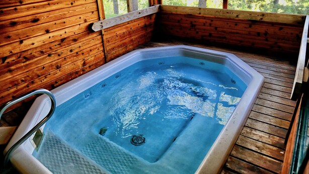 En stuga av trä med ett bubbelbad.