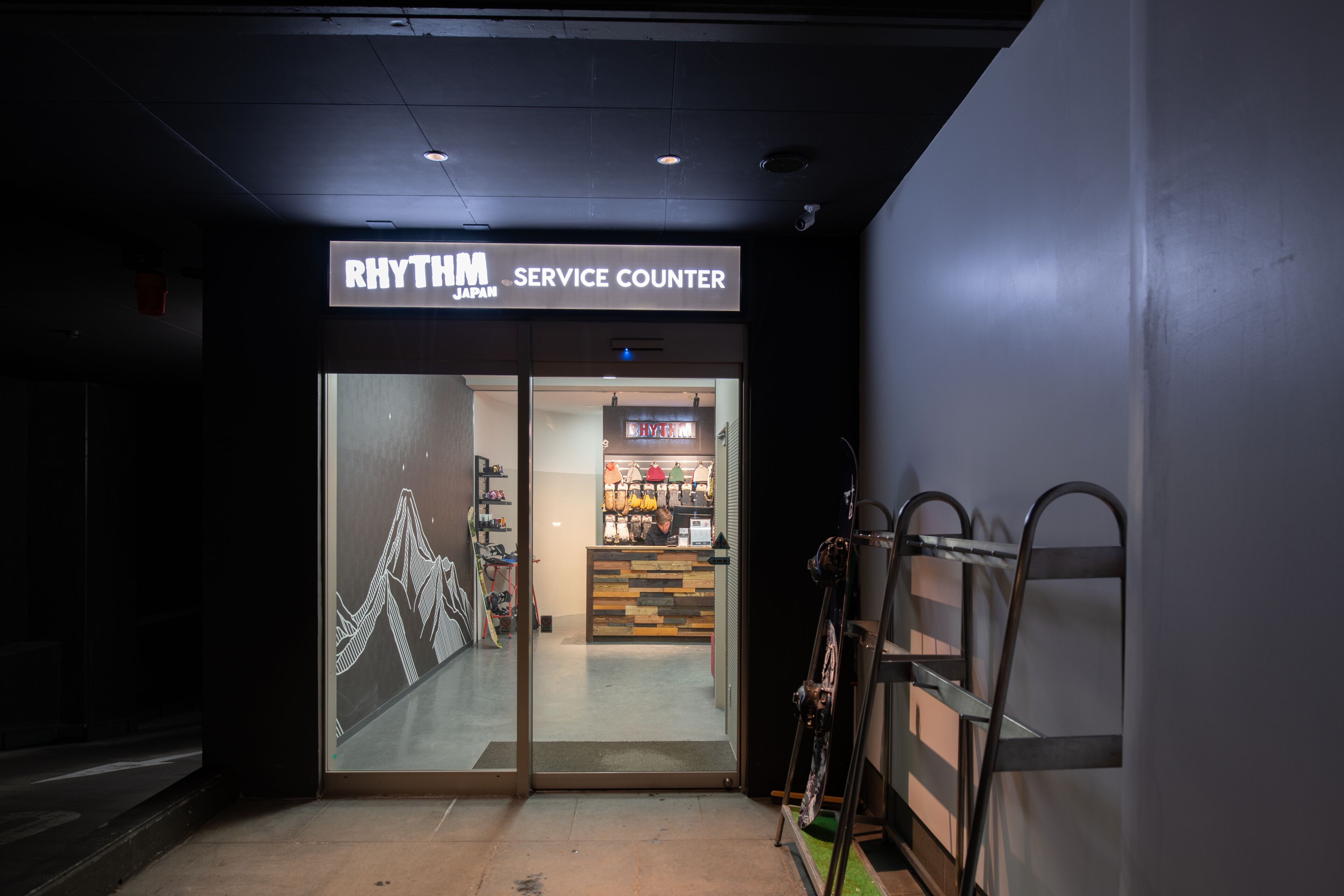 Ingången till en servicepunkt med en skylt som visar texten: ”Rhythm Service Counter Japan”.