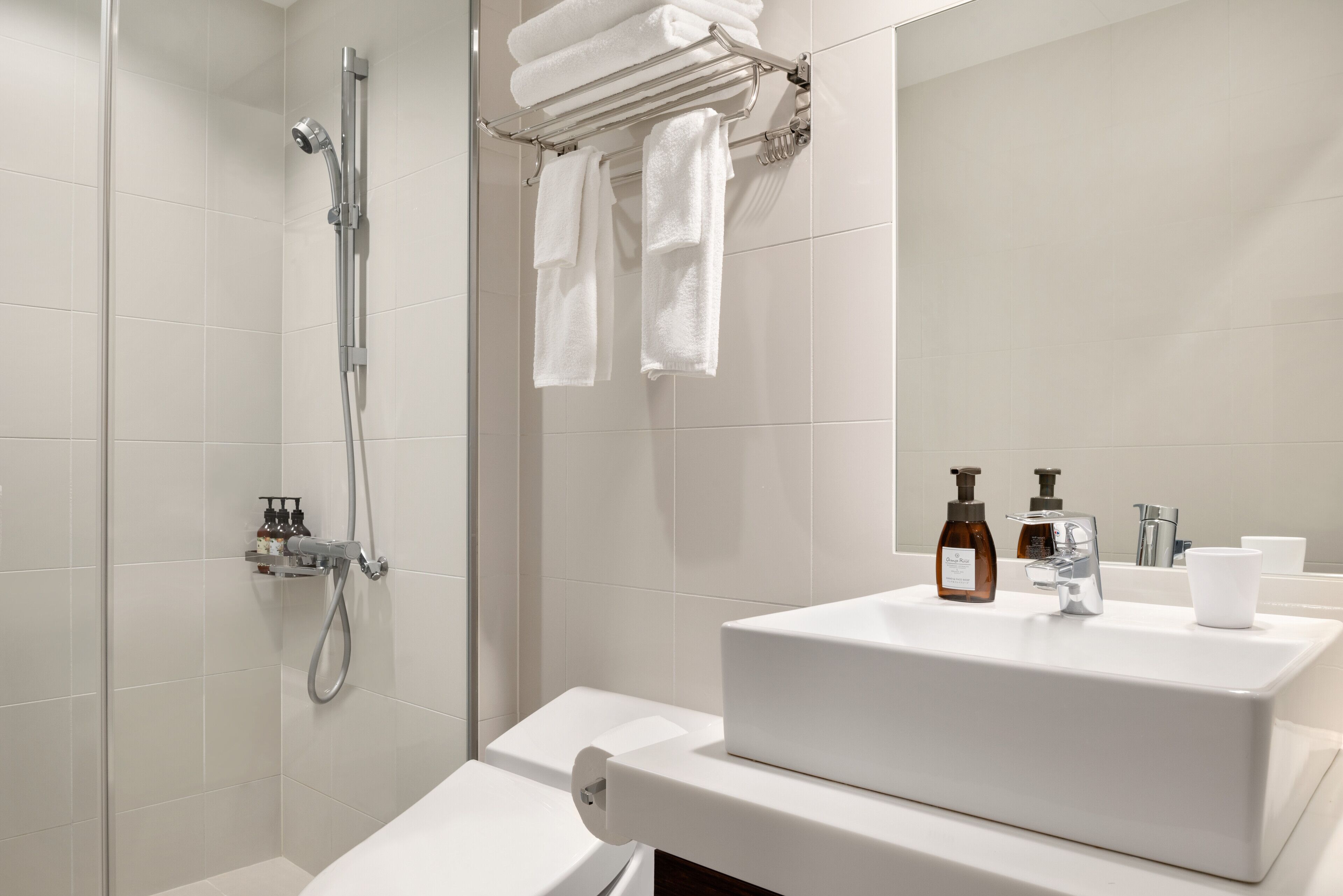 Un baño moderno con ducha, inodoro y lavamanos.