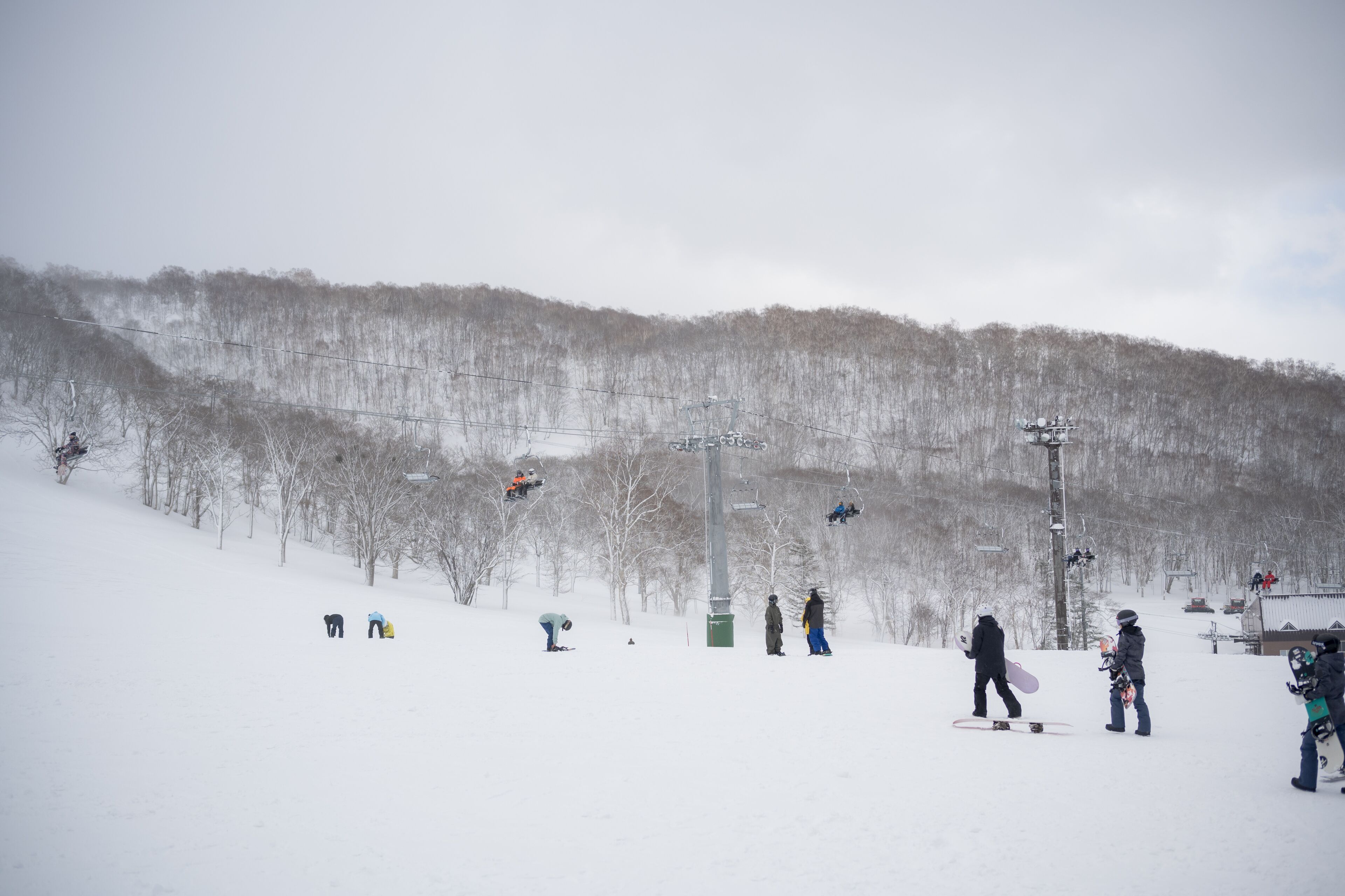 Pista de esquí nevada con esquiadores y snowboarders.