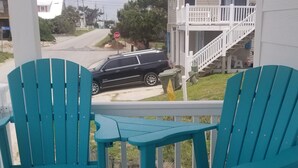 En veranda med to turkise Adirondack-stole og et lille bord.