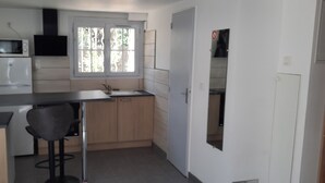 A compact kitchen with a microwave, a sink, and a window.