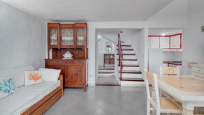 Eine moderne Küche mit weißen Schränken, einem Holzespeisetisch und einer Treppe zu einem Schlafzimmer im oberen Bereich.