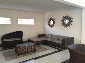 A living room with a sofa, a loveseat, a coffee table, and two wall-mounted mirrors. - Sueds Segundo Sol Praia Hotel (Santa Cruz Cabralia)