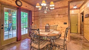 A wooden interior with a dining table, chairs, and a chandelier. - Spacious Family Home w/ Fire Pit by Norfork Lake! (Mountain Home)
