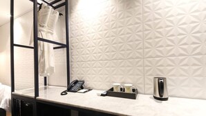 A hotel bathroom with a mirror, a towel rack, a telephone, a tray with mugs, and a kettle. - Sinan E.KKLIM Hotel (Gwangju)