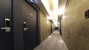 A hallway with doors marked with room numbers, carpeted flooring, and a modern design. - Sinan E.KKLIM Hotel (Gwangju)