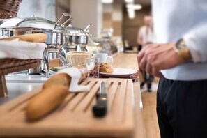 A buffet setup with various food items and a person in the background. - Brauereigasthof Flair-Hotel Sperber-Bräu (Sulzbach-Rosenberg)