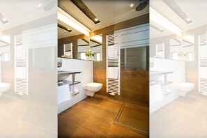 A modern bathroom with a wooden floor, white fixtures, and a large mirror. - Brauereigasthof Flair-Hotel Sperber-Bräu (Sulzbach-Rosenberg)