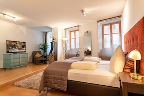 A modern bedroom with a bed, a TV, a desk, and a window with blinds. - Brauereigasthof Flair-Hotel Sperber-Bräu (Sulzbach-Rosenberg)