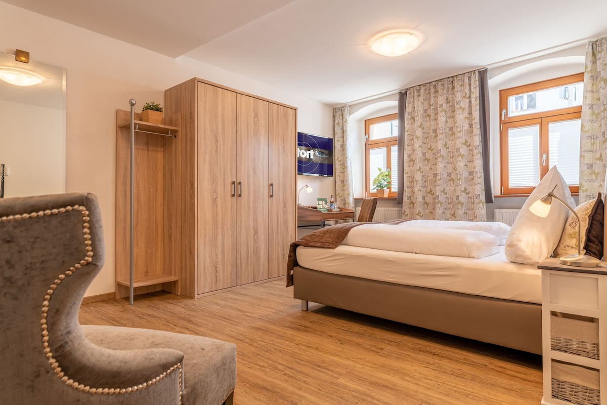 A modern bedroom with a bed, a wardrobe, a desk, and a chair.