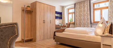 Un dormitorio moderno con cama, armario, escritorio y silla.