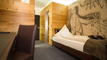 Una habitación moderna con una pared de madera, una cama con almohadas y una silla.