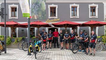 Un grupo de ciclistas frente a un edificio con un letrero que dice 'Sperber'.