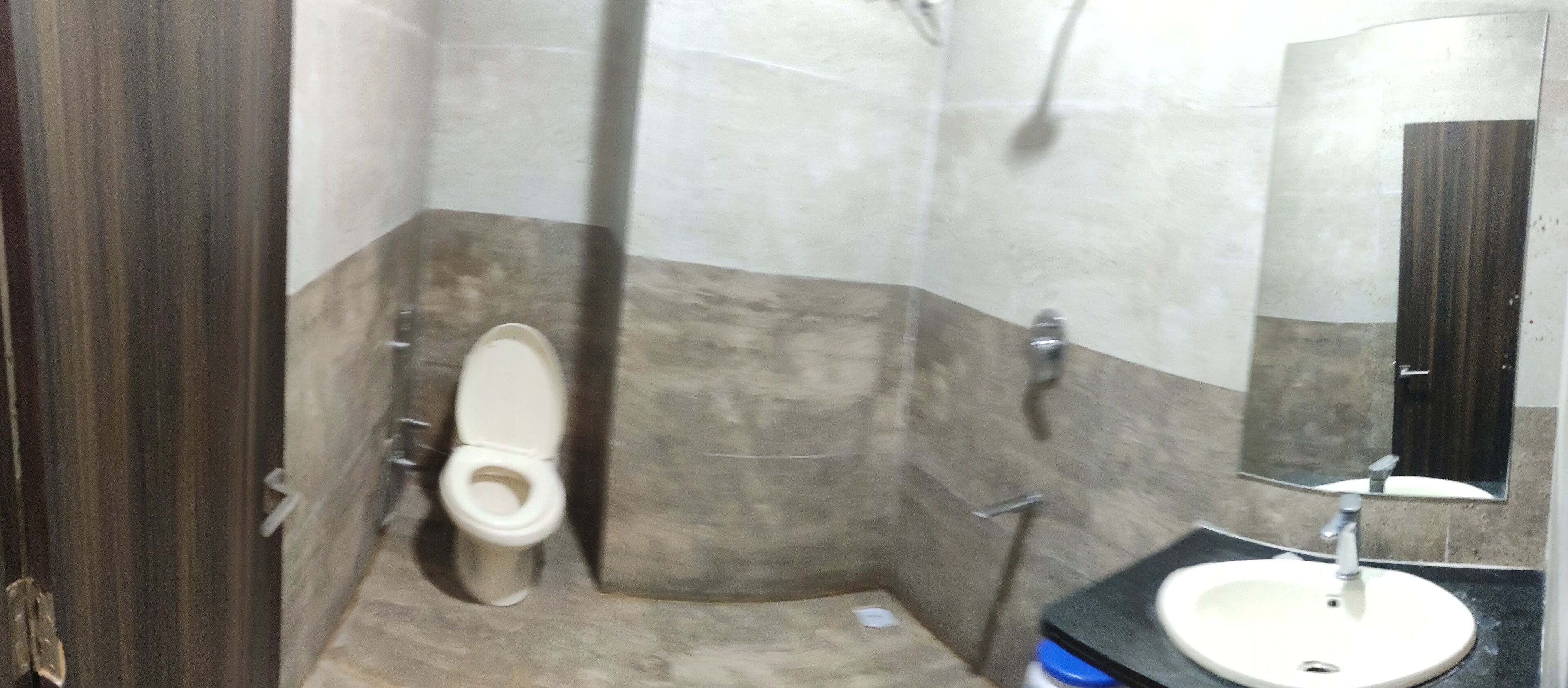 A bathroom with a toilet, sink, and mirror.