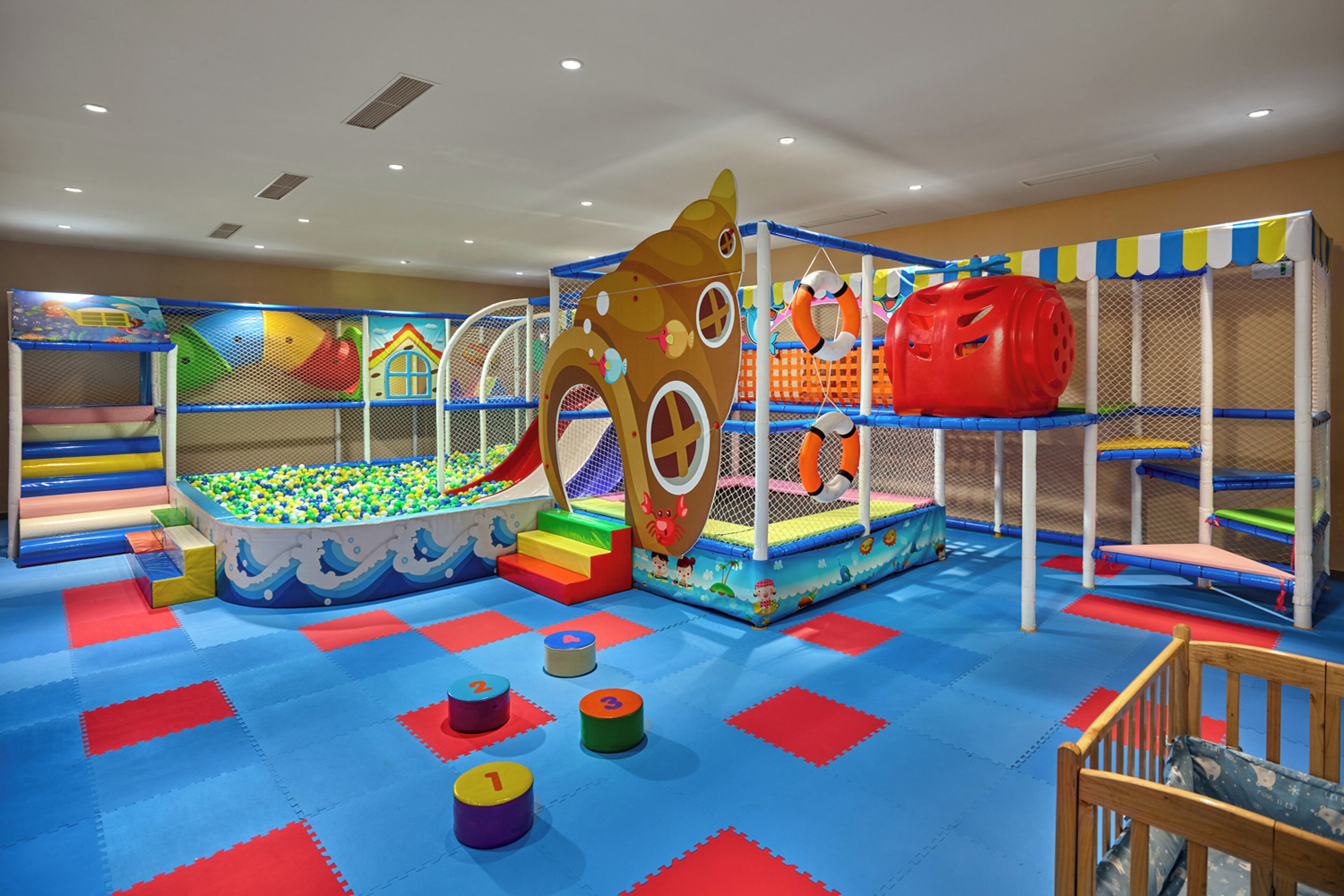 Un área de juegos infantiles con piscina de pelotas, toboganes y estructuras para escalar.