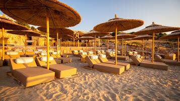 On the beach, white sand, sun-loungers, beach bar