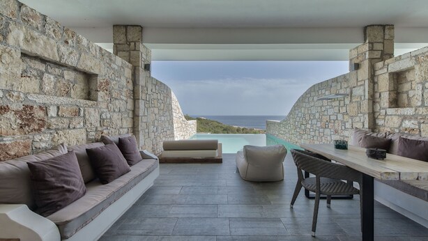 A stone-walled outdoor seating area with a view of the sea. - Aliv Stone Suites & Spa (Zakynthos)