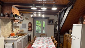 A kitchen with a dining table, chairs, a stove, and a refrigerator. - Individual countryside house in a small village (Cercles)