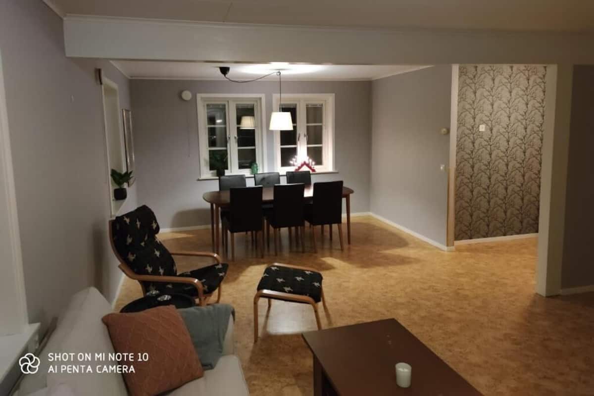 A living room with a sofa, a coffee table, and a dining area with a table and chairs.