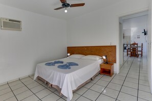 A bedroom with a bed, nightstand, and ceiling fan. - Marazul Apart Hotel II (Florianopolis)