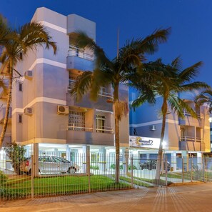 A multi-story hotel with a modern design, featuring balconies and a well-lit entrance. - Marazul Apart Hotel II (Florianopolis)