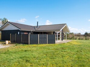 A single-story house with a dark exterior, a tiled roof, and a covered porch. - Holiday Home in Ansager (Ansager)