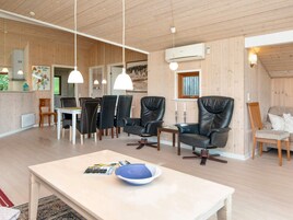 Un interior moderno con comedor, asientos y cocina.