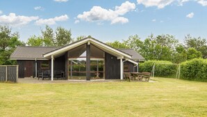 A building with a large open patio area, a covered seating area, and a sports field. - Holiday Home in Ansager (Ansager)