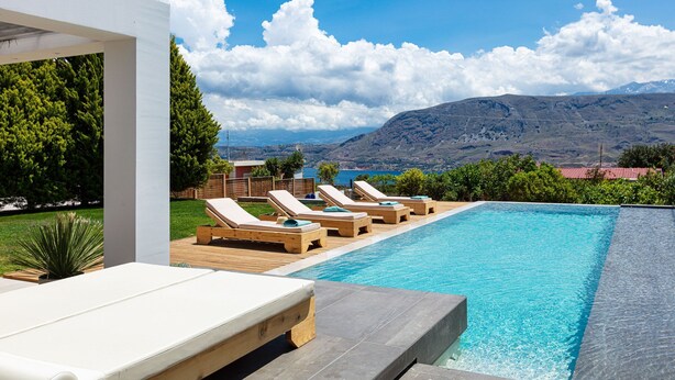 A pool with lounge chairs and a view of mountains. - Luxury Ensuite Villa Overlooking Souda Bay (Chania)