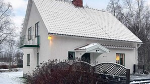 A white house with a steep roof, a visible chimney, and a gated entrance. - 7 Person Holiday Home in Docksta (Docksta)