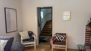 A living room with a sofa, two armchairs, a staircase, and a framed picture on the wall. - 7 Person Holiday Home in Docksta (Docksta)
