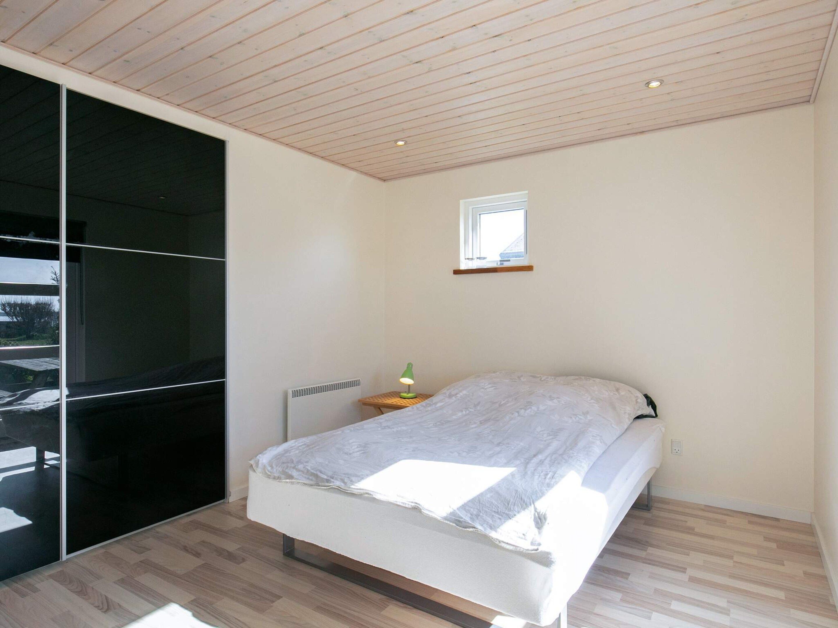 A bedroom with a bed, a window, and a radiator.