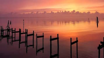 A calm lake at sunrise with wooden docks extending into the water.
