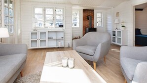 Una sala de estar acogedora con chimenea, un sofá, una mesita de centro y una estantería.