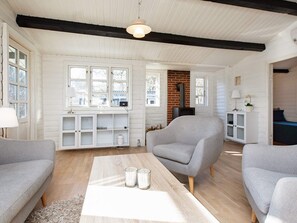 A cozy living room with a fireplace, a sofa, a coffee table, and a bookshelf. - 7 Person Holiday Home in Vig (Vig)