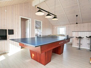 A ping pong table with a wooden base and a black playing surface, set in a room with wooden walls and floors. There are two hanging pendant lights above the table. - Holiday Home in HarboÃ¸re (Harboore)