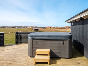 A hot tub on a wooden deck with a view of houses in the background. - Holiday Home in HarboÃ¸re (Harboore)