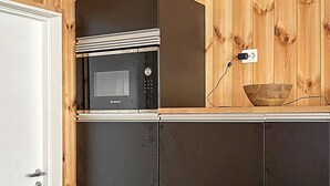 Uma cozinha com micro-ondas Bosch, uma tigela de madeira e uma tomada na parede.