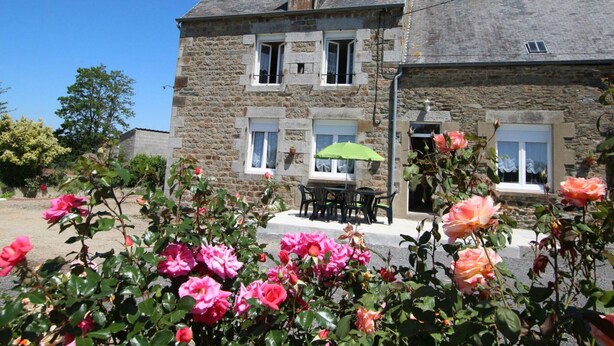 A stone building with a balcony and a table with chairs. - Family Home with Garden Near Mont St Michel - 3BR, 2BA, WiFi, Baby Gear, Linens Included (Céaux)
