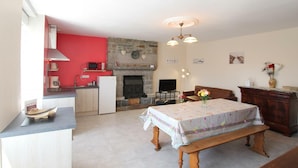 A compact living space with a kitchen, dining area, and a fireplace. - Family Home with Garden Near Mont St Michel - 3BR, 2BA, WiFi, Baby Gear, Linens Included (Céaux)