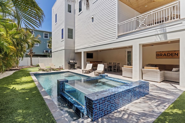 A modern house with a swimming pool, outdoor seating, and a sign for 'BRADEN'.