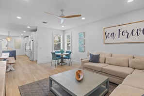 A modern living room with a sofa, coffee table, and dining area.