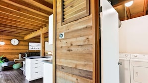 A modern kitchen with wooden accents, a built-in oven, and a clock on the wall. - Cozy Updated Sunriver Cabin, 6 SHARC Passes, Floor to Ceiling Windows, Golf, Swim, Ski, and Explore (Sunriver)