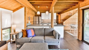 A modern log cabin interior with a living area, kitchen, and dining space. - Cozy Updated Sunriver Cabin, 6 SHARC Passes, Floor to Ceiling Windows, Golf, Swim, Ski, and Explore (Sunriver)