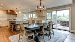 Una cocina amplia con una isla grande, armarios de madera y un candelabro.